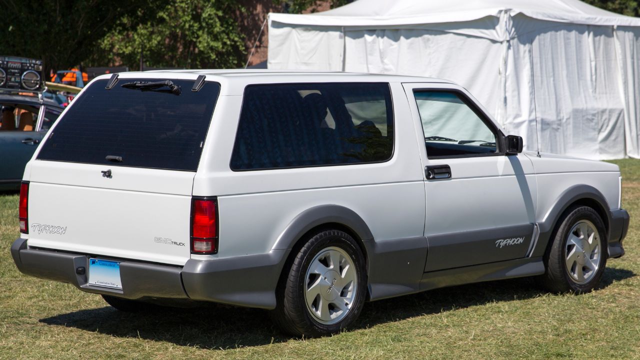 White GMC Typhoon with gray bumpers and side skirts rear 3/4 view parked
