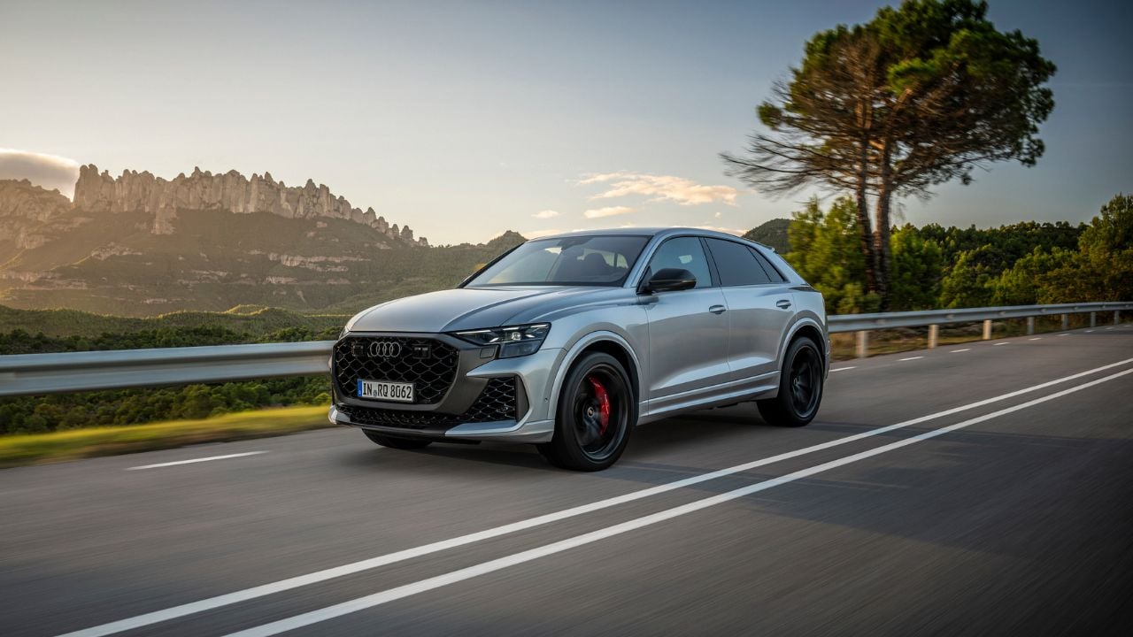 Grey 2026 Audi RS Q8 performance front 3/4 driving on a road