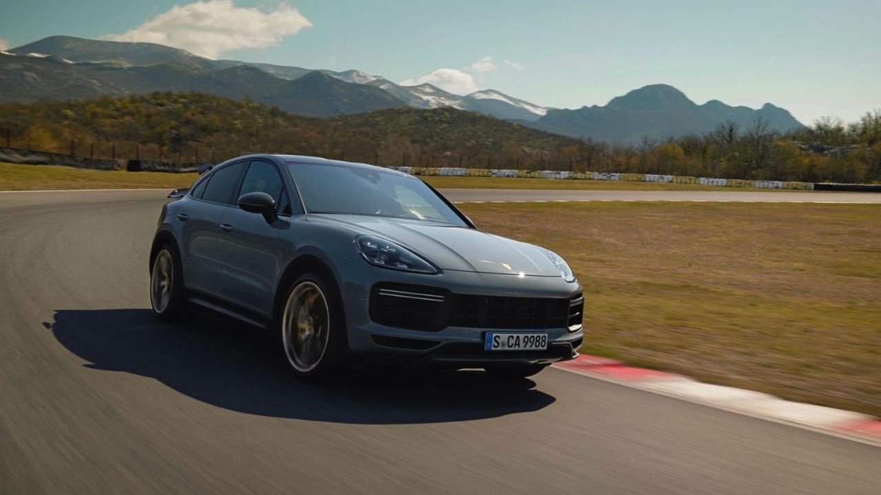 2026 Porsche Cayenne Turbo GT front 3/4 view driving on a track