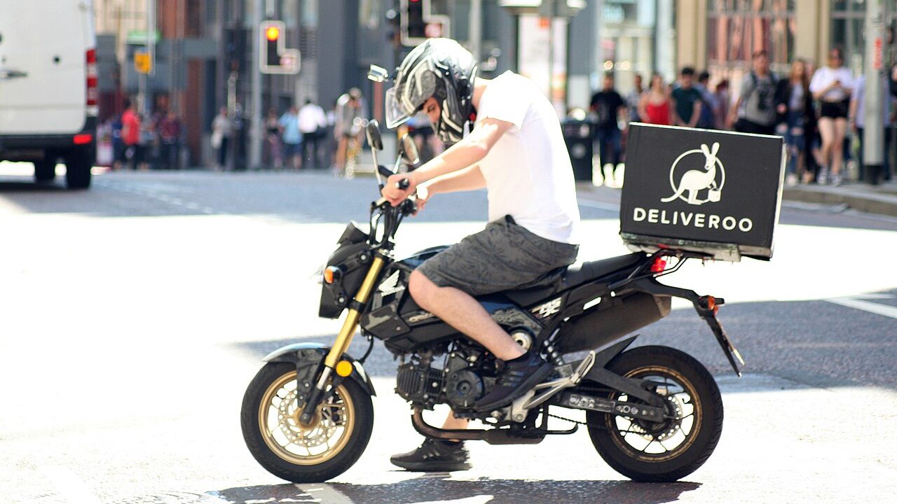Deliveroo driver on a motorbike in Manchester.