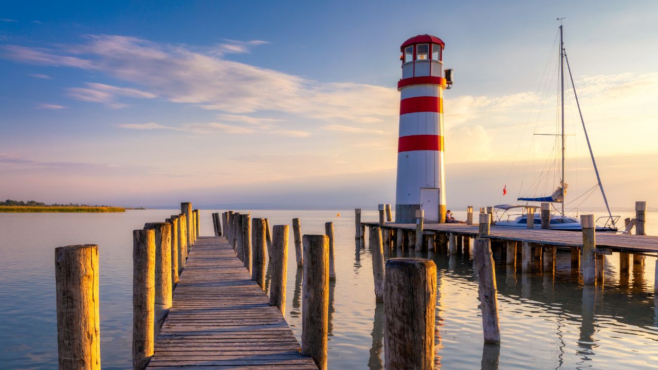 Lighthouse at Lake Neusiedl, Podersdorf am See, Burgenland, Austria. Lighthouse at sunset in Austria. Wooden pier with lighthouse in Podersdorf on lake Neusiedl in Austria.