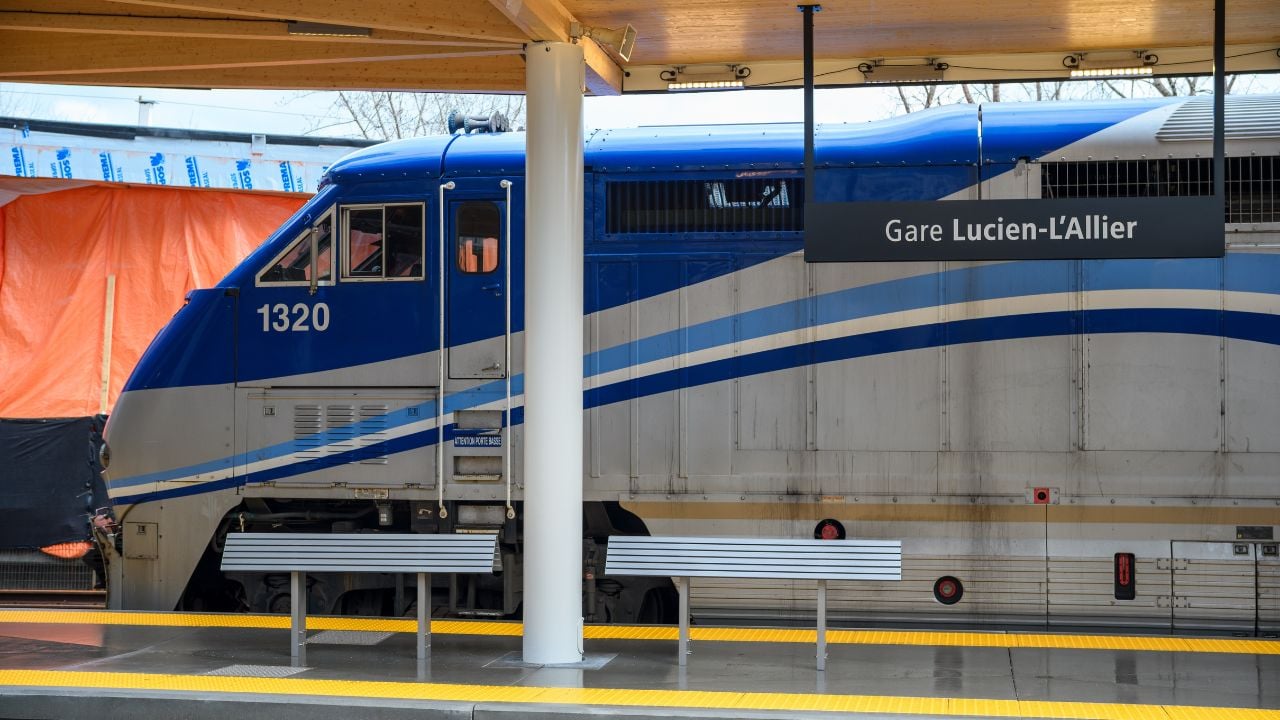 Montreal, Canada – April 03 2025: Side view of an Exo Commuter Train Locomotive at Lucien L'Allier Station with Station Signage