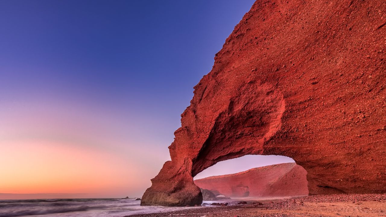 Sunset at red arches of Legzira beach, Sidi Ifni, Souss-Massa-Draa, Morocco.