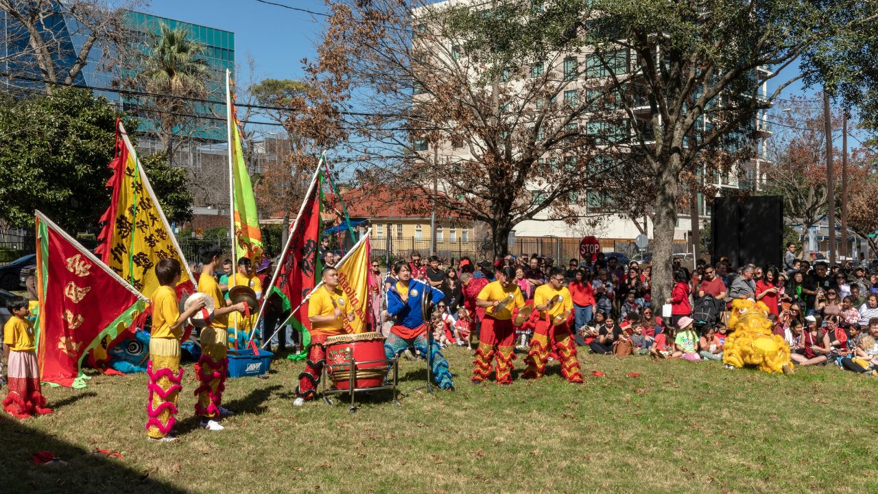 Houston, Texas, USA - February 2, 2025: Traditional Chinese Dragon and Lion Dance Performance with Colorful Flags and Drums at Lunar New Year Festival Celebration in Houston, Texas Urban Park Setting