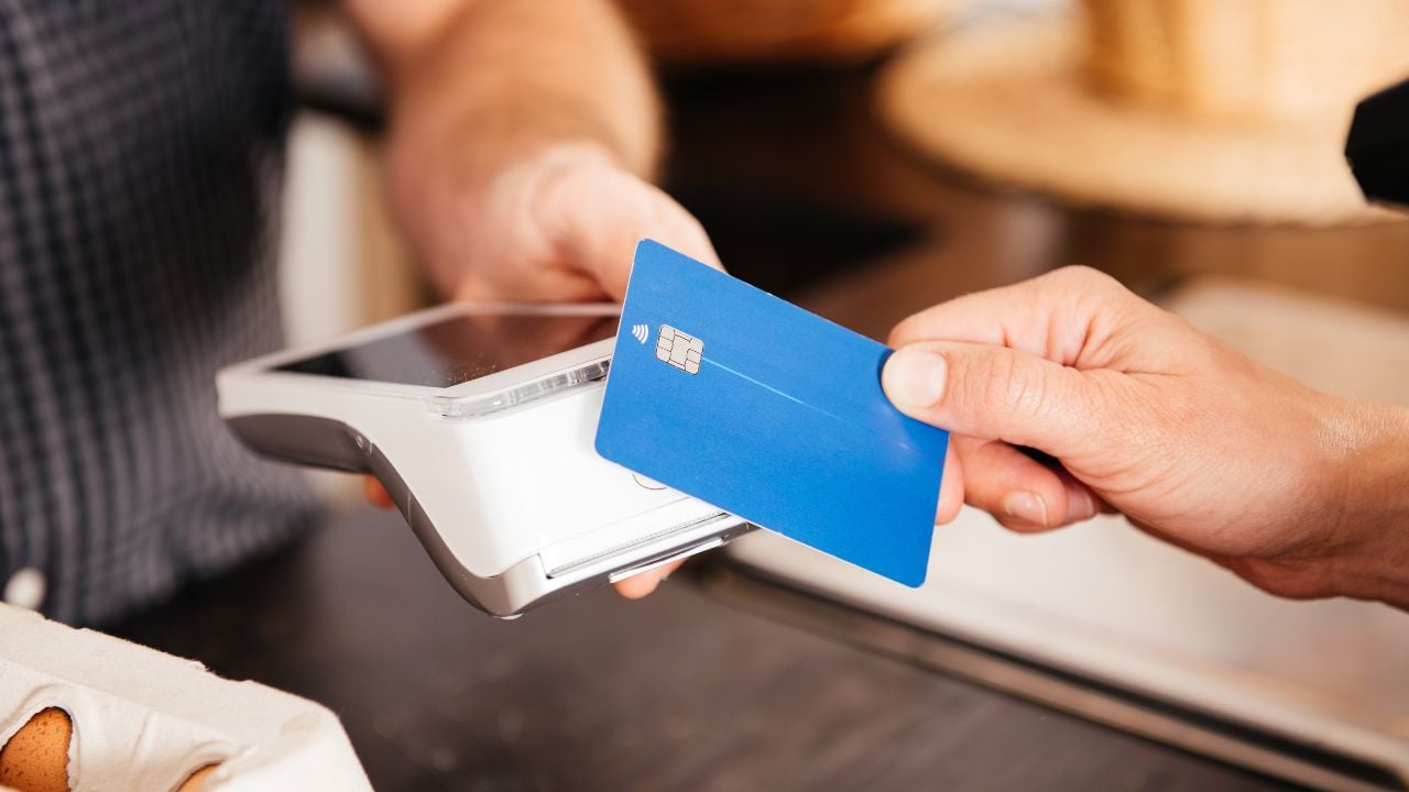 Customer paying by credit card at a checkout counter.