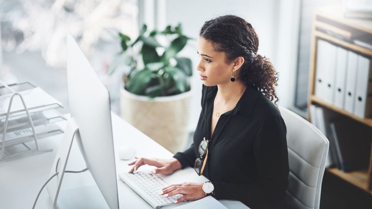 Corporate, typing and a woman with an email on a computer, research or secretary work. Analytics, desk and a female receptionist with a pc in an office for communication, connectivity and working
