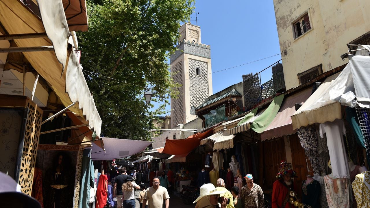 FEZ, MOROCCO – JUNE 1, 2025: Tourists and local people doing their shopping in the world biggest medina, bazaar of Fez, Morocco