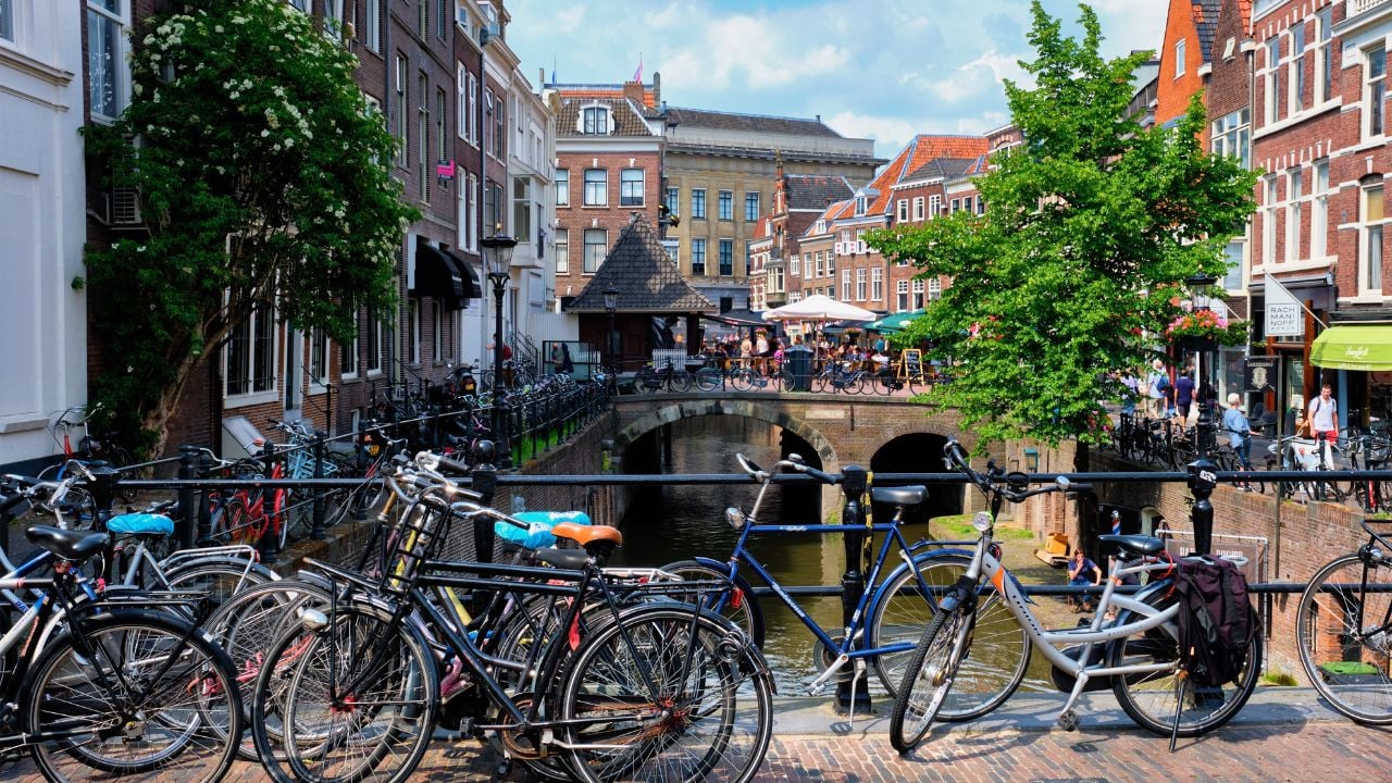 UTRECHT, NETHERLANDS - MAY 25, 2018: Bicycles which are a very popular transport in Netherlands parked in street along the canal near old houses. Utrecht, Netherlands