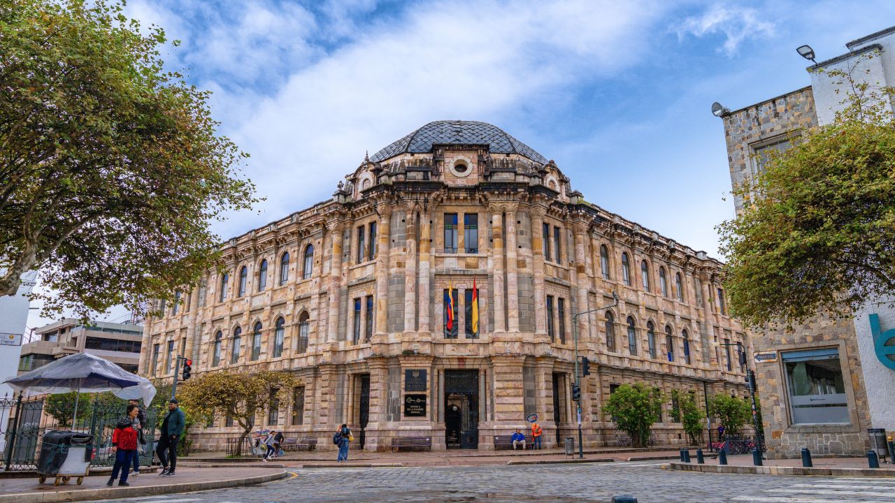 Cuenca, Ecuador – March 1, 2025: Street view of the Provincial Court of Justice of Azuay, a neoclassical building in Cuenca’s historic center, with pedestrians nearby.