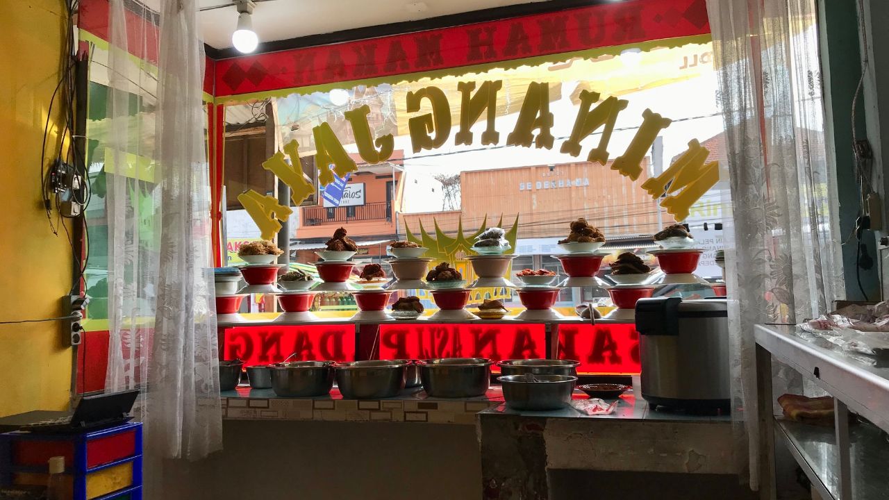 Lawang, Indonesia - July 5 2024: Various traditional Padang foods are displayed in a glass display case at Padang restaurant 'Minang Jaya', Lawang, Indonesia.