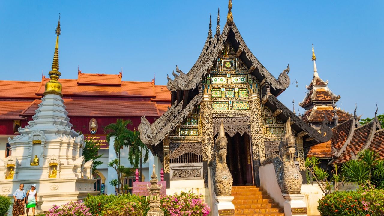 Chiang Mai,Thailand-May 4th 2024:Exterior view of Wat Chiang Man-3th-century temple with a gold chedi offering ancient Buddha and elephant statues on scenic grounds.