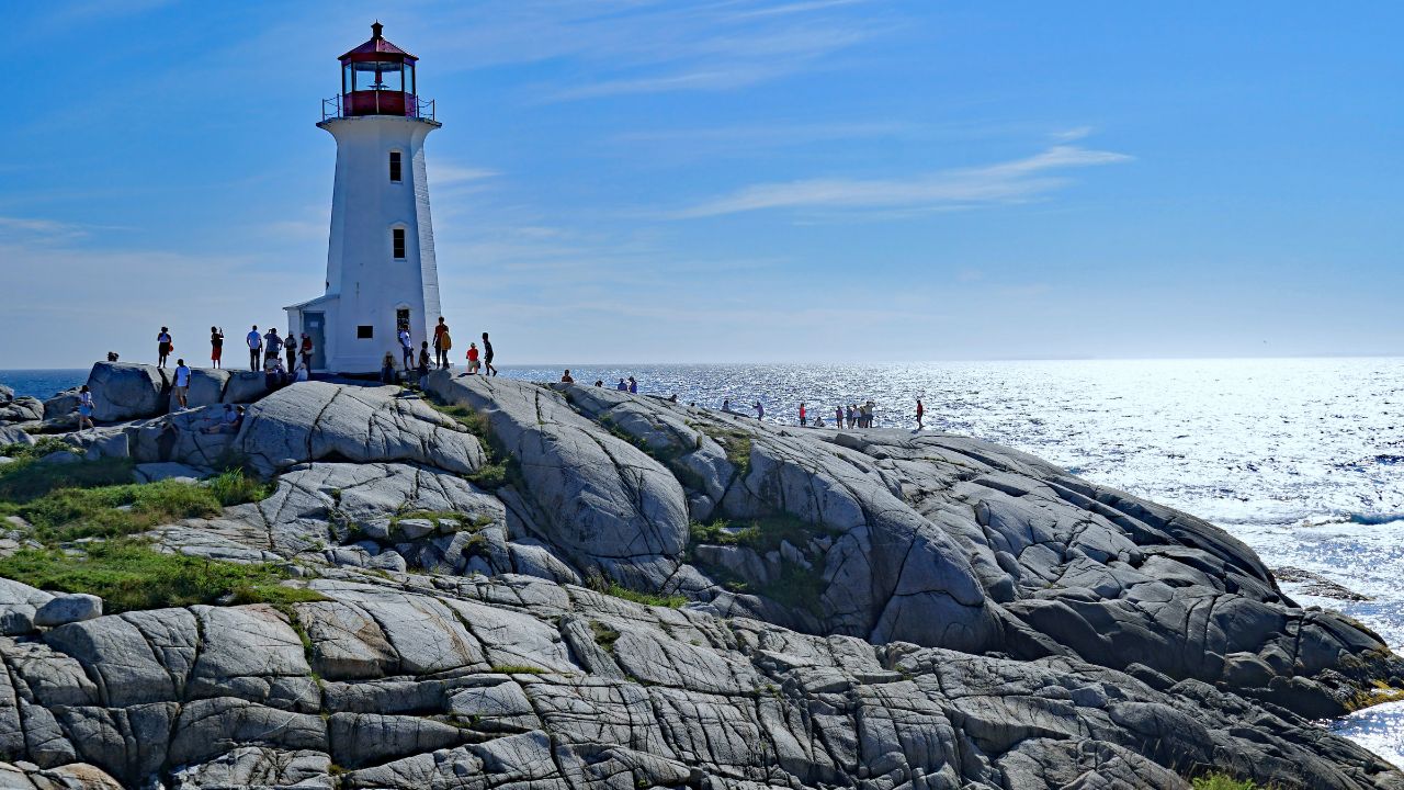 PEGGY'S COVE, NOVA SCOTIA - AUGUST 2019: The lighthouse and the unique rock formations on which it rests are a popular attraction for visitors on the Atlantic coast.