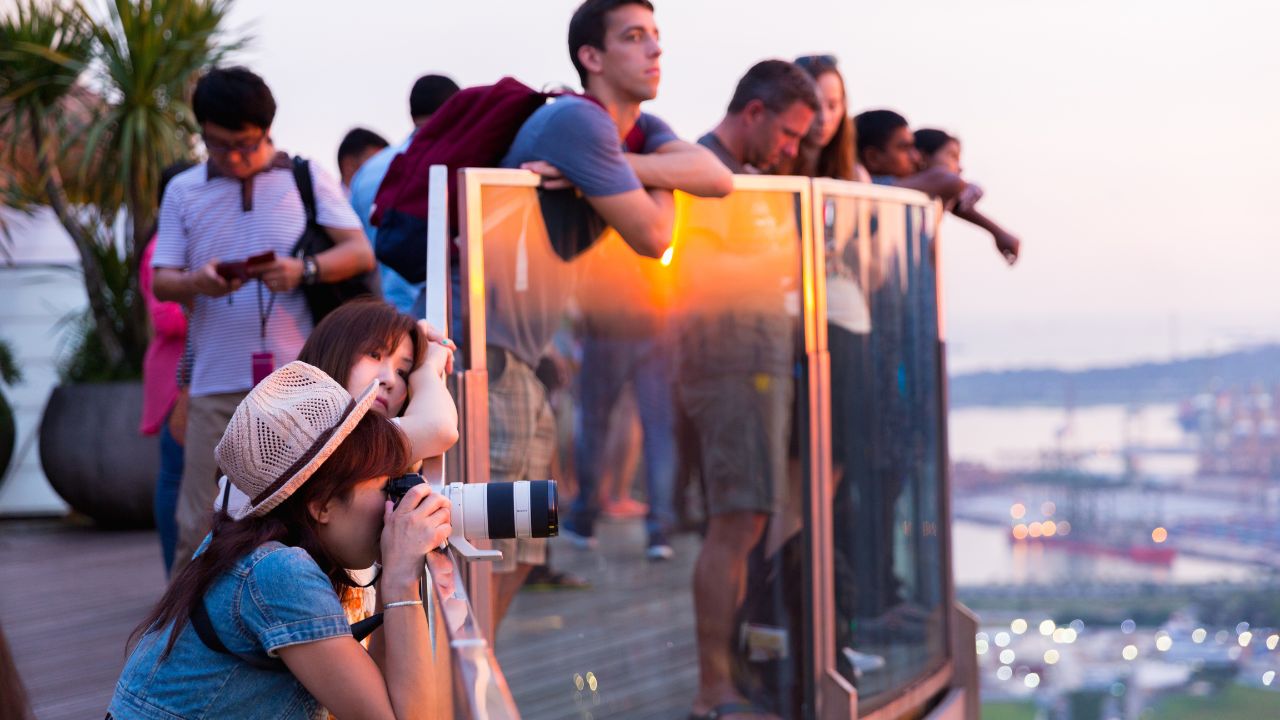 MARINA BAY SAND, SINGAPORE - MAY 12, 2017: Tourists looking panoramic views sunset from Observation Deck Skypark of Marina Bay Sands hotel and casino.