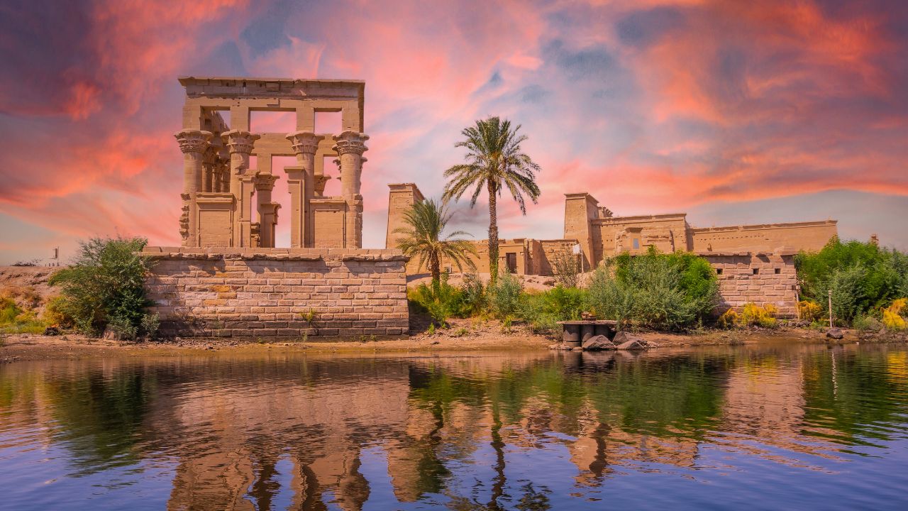 Incredible orange sunrise at the temple of Philae, a Greco-Roman construction seen from the Nile river, a temple dedicated to Isis, goddess of love. Aswan. Egyptian
