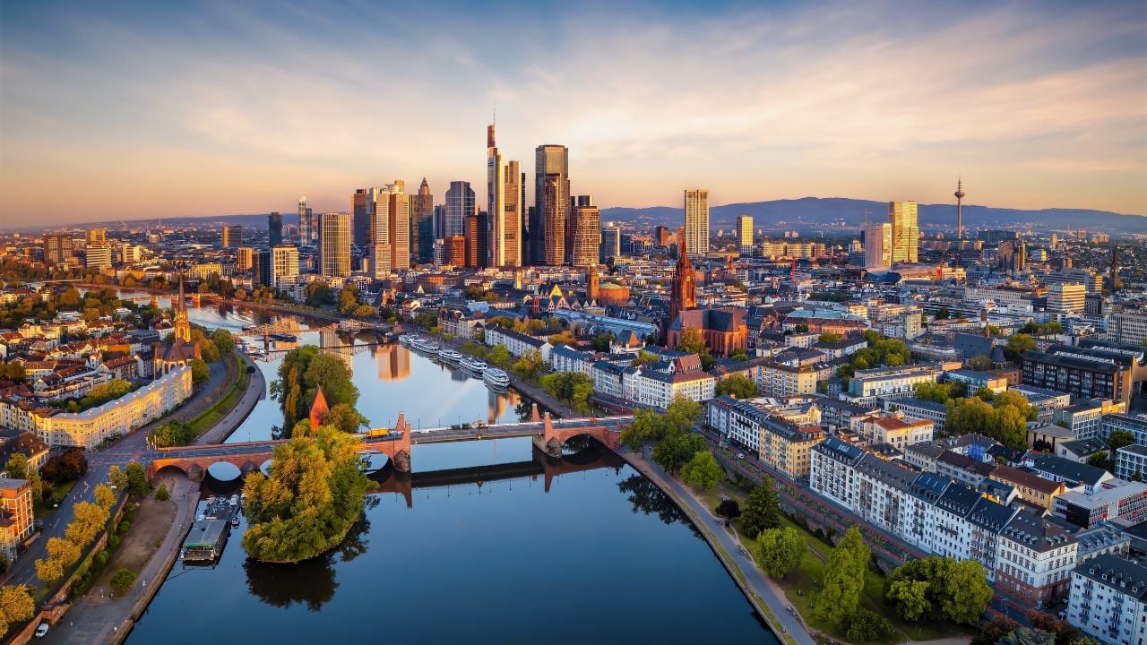 Panoramic aerial view of the skyline of Frankfurt am Main, Germany, with golden morning sunlight reflecting from the office skyscrapers