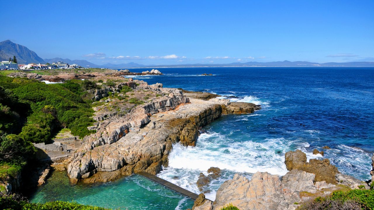 Beautiful Atlantic Ocean coast in Hermanus with waves crashing on the shore on sunny day, South Africa