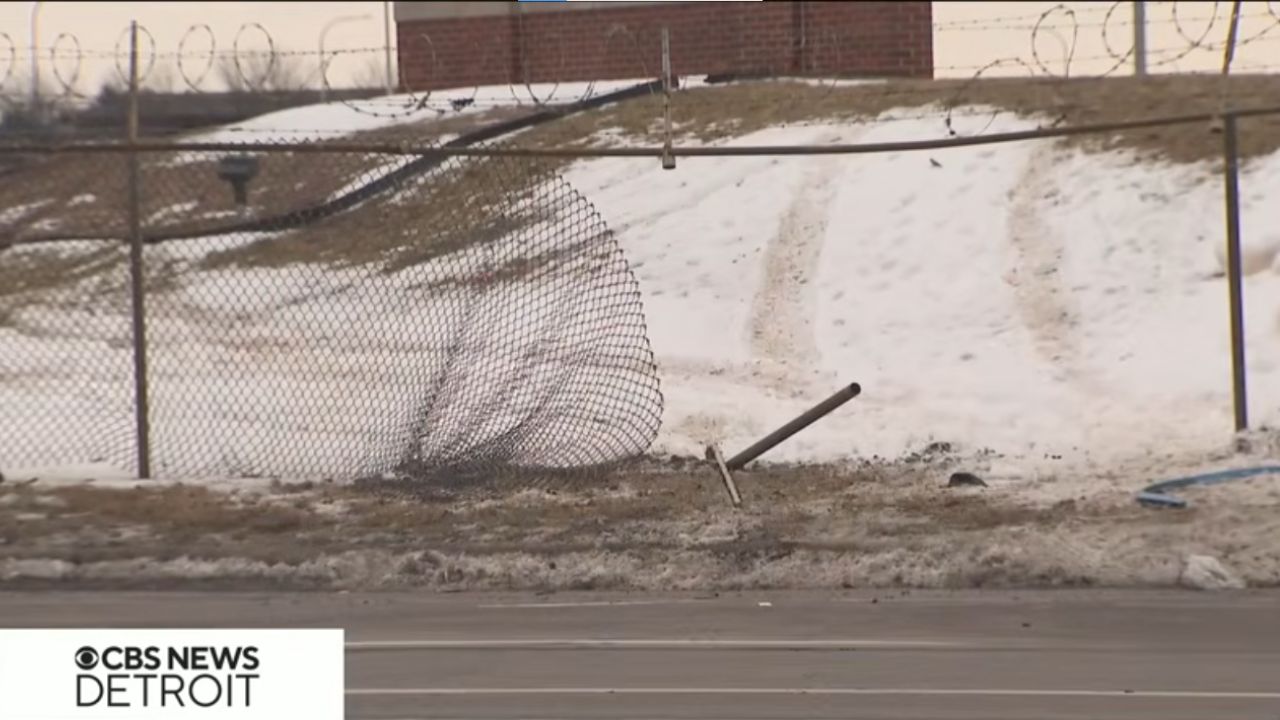 Torn fence of a car storage lot.