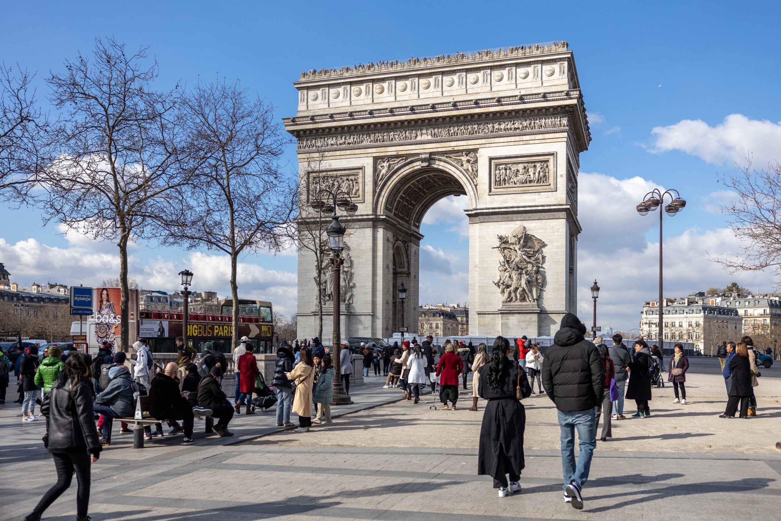 Paris, France - February 28 2023: Many people at place Charles de Gaulle to see the Arc de Triomphe on a beautiful sunny day in March