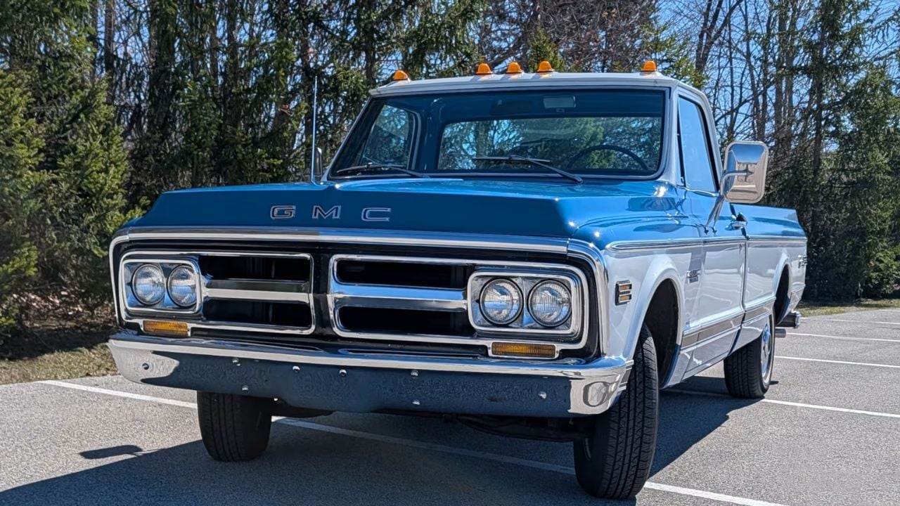 A blue 1972 GMC Sierra Pickup in the sunshine in a forest.