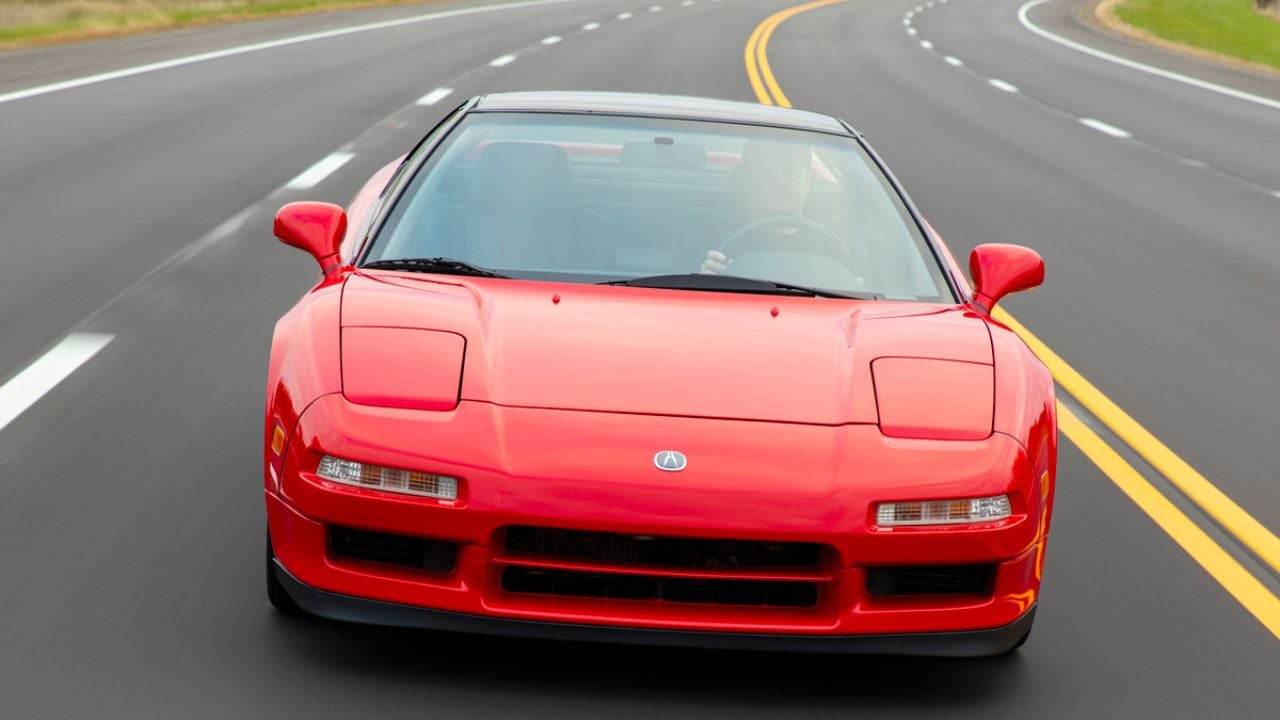 Front view of a Red 1991 Acura NSX driving on a road
