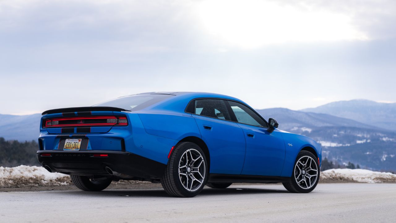 Rear 3/4 view of a Blue SIXPACK-powered 2026 Dodge Charger R/T parked in snow