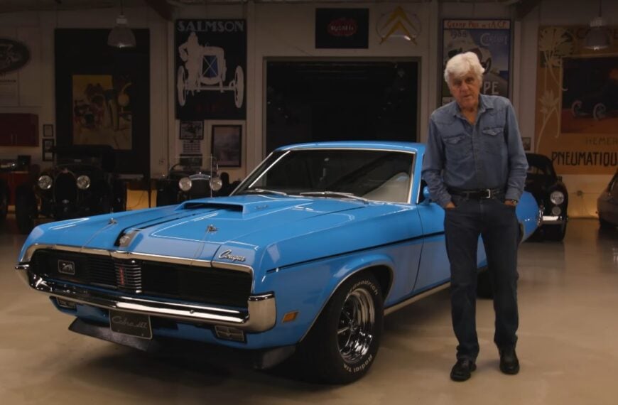 Front 3/4 shot of a Competition Blue 1969 Mercury Cougar Eliminator featured on Jay Leno's Garage with Jay Leno standing next to it