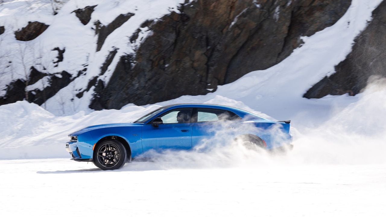 Side view of a Blue SIXPACK-powered 2026 Dodge Charger R/T driving in the snow