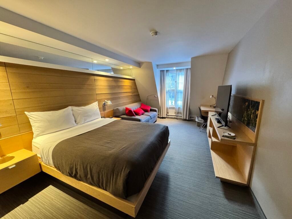Hotel room with bed, desk, and window
