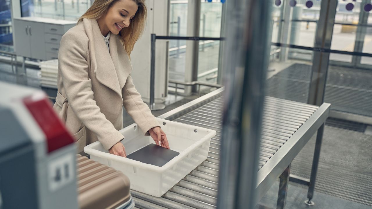 Tender young female person keeping smile on her face while standing at checkpoint in the airport