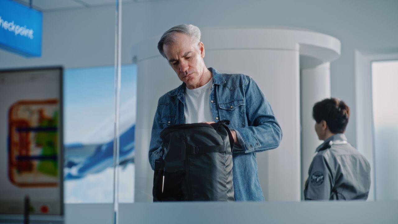 Airport Terminal Checkpoint: Diverse Passengers During Security Check with Hand Luggage and Bags. Advanced Analyzing Program with X-ray Metal Detector Scanning of Baggage Displayed on Computer Monitor