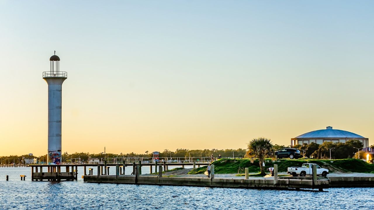 The sun sets on the Broadwater Beach Marina channel lighthouse and Mississippi Gulf Coast Coliseum (right), Feb. 24, 2019, in Biloxi, Mississippi. The open-lantern style lighthouse was built in 1965.
