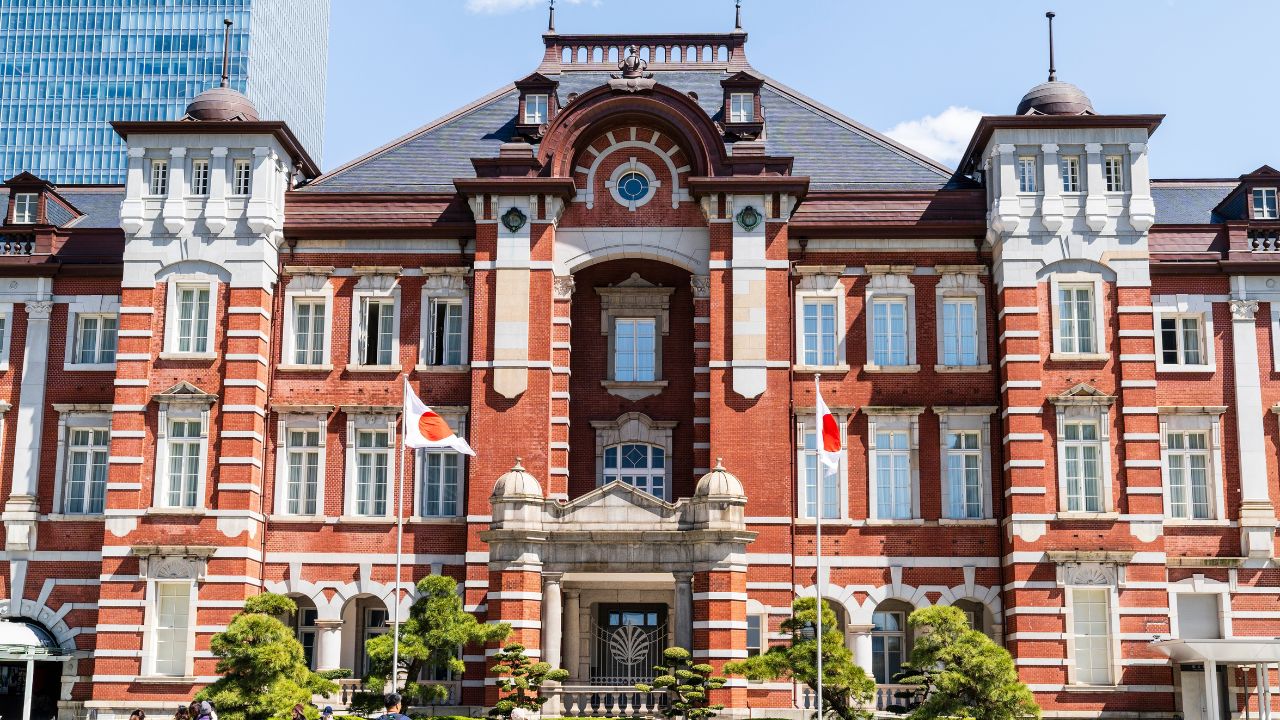 Tokyo, Japan. April 9, 2019. The Marunouchi side of the iconic red brick Tokyo station building with people in foreground. Central part of the building with the now closed main entrance. Blue sky.