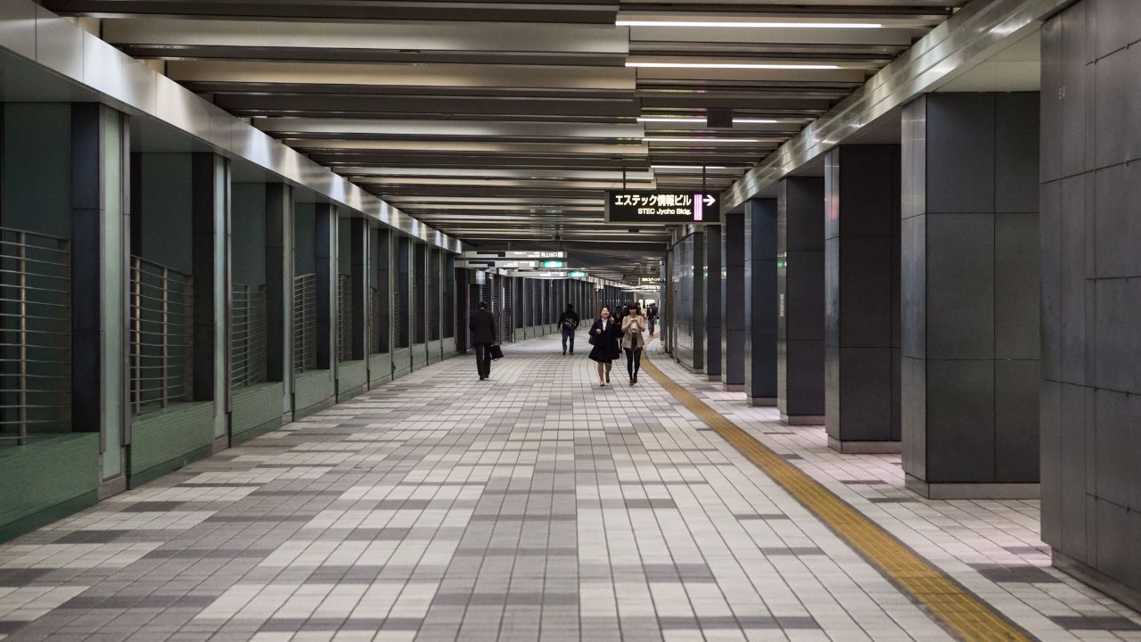 TOKYO, JAPAN-CIRCA APR 2013: People walk in pedestrian undercrossing at night time. Empty wide tunnel under central part buidings. Business district is in Shinjuku