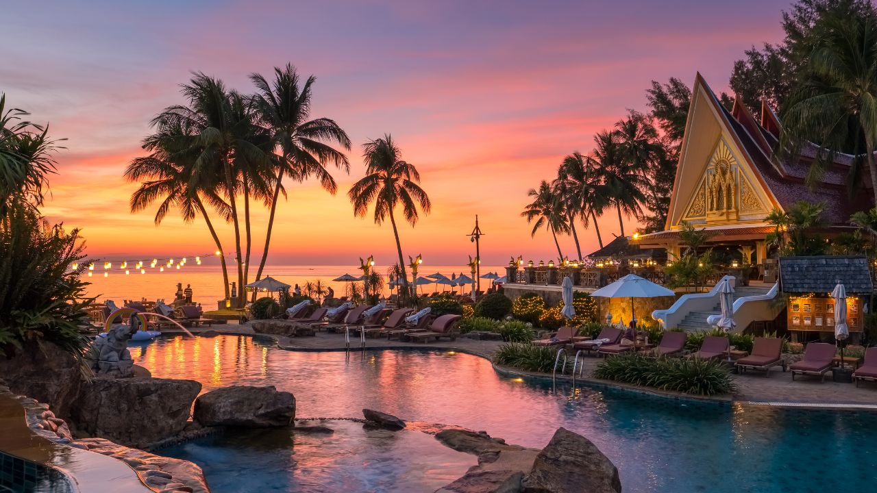 Koh Chang, Thailand - December 18, 2018: Beautiful sunset view with palm trees reflecting in swimming pool in luxury island resort in Thailand