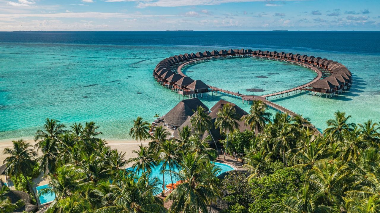 Picturesque aerial landscape Maldives water villas tropical paradise island turquoise lagoon bay horizon blue sky sunny day luxury travel summer vacation exotic coast scenic ocean holiday wallpaper