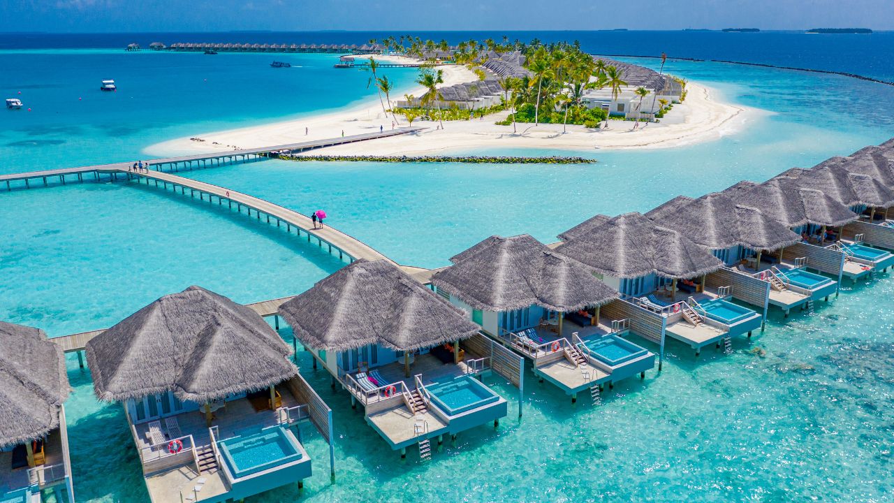 Aerial view of Maldives island with luxury water villas and clear lagoon