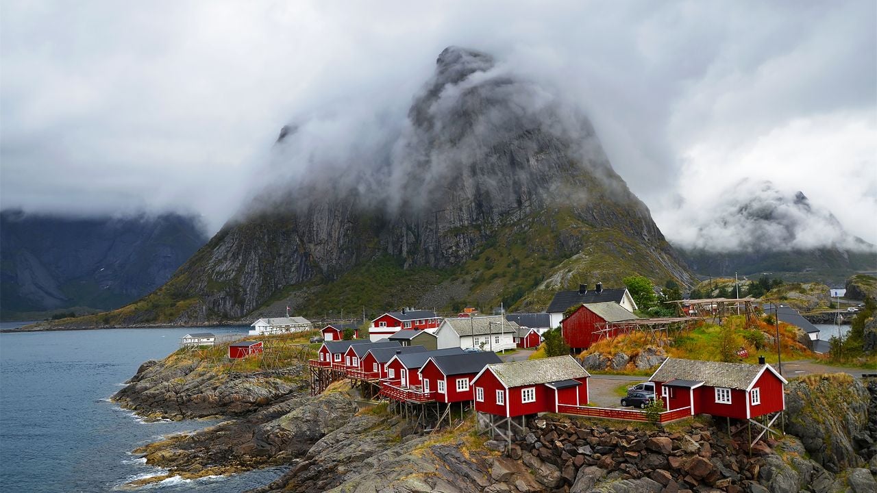 Small fishing village in Norway with wooden houses and mountains