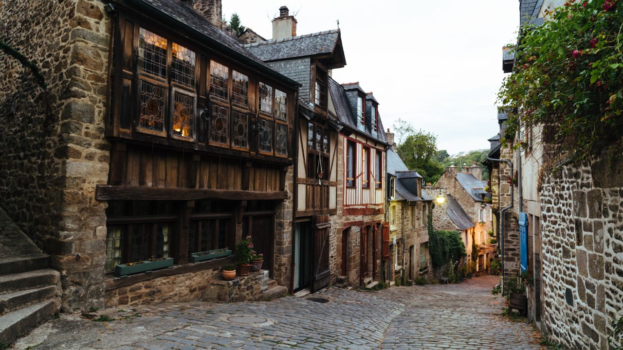 Dinan, France - July 23, 2018: Old cobblestoned street with medieval houses at dusk, French Brittany