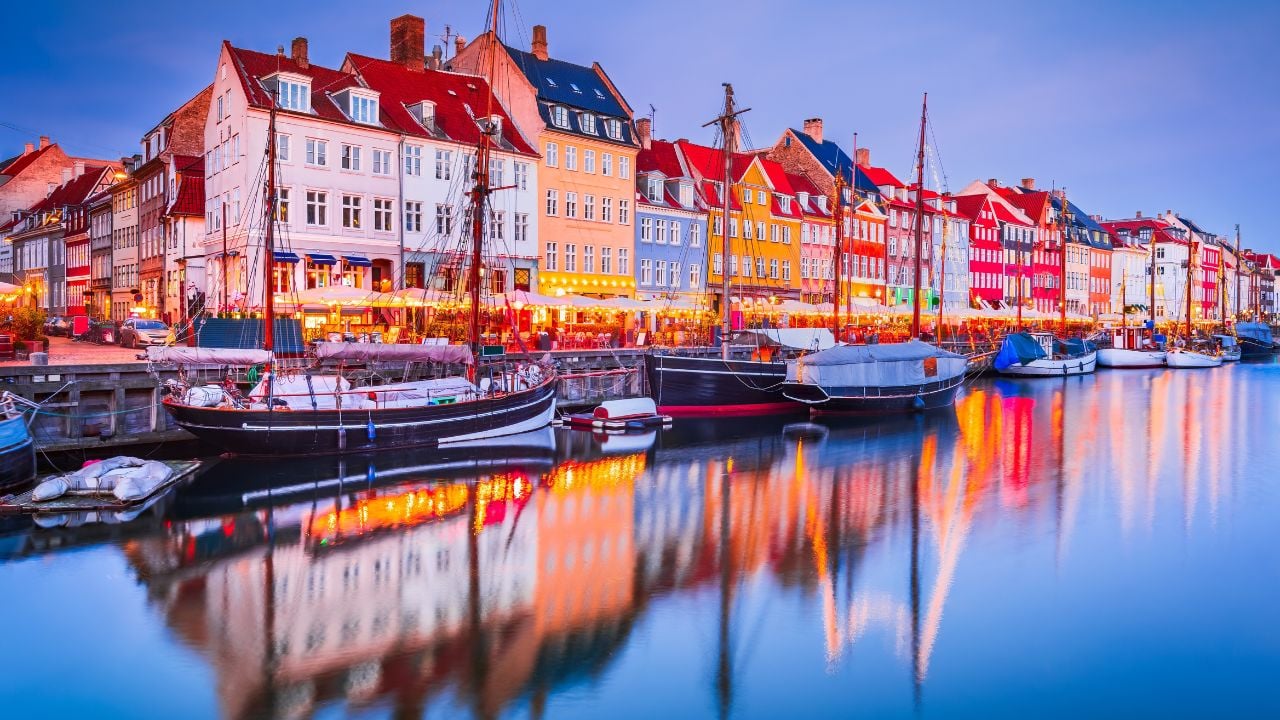 Charm of Copenhagen, Denmark at Nyhavn. Iconic canal, colorful morning twilight with breathtaking water reflections.