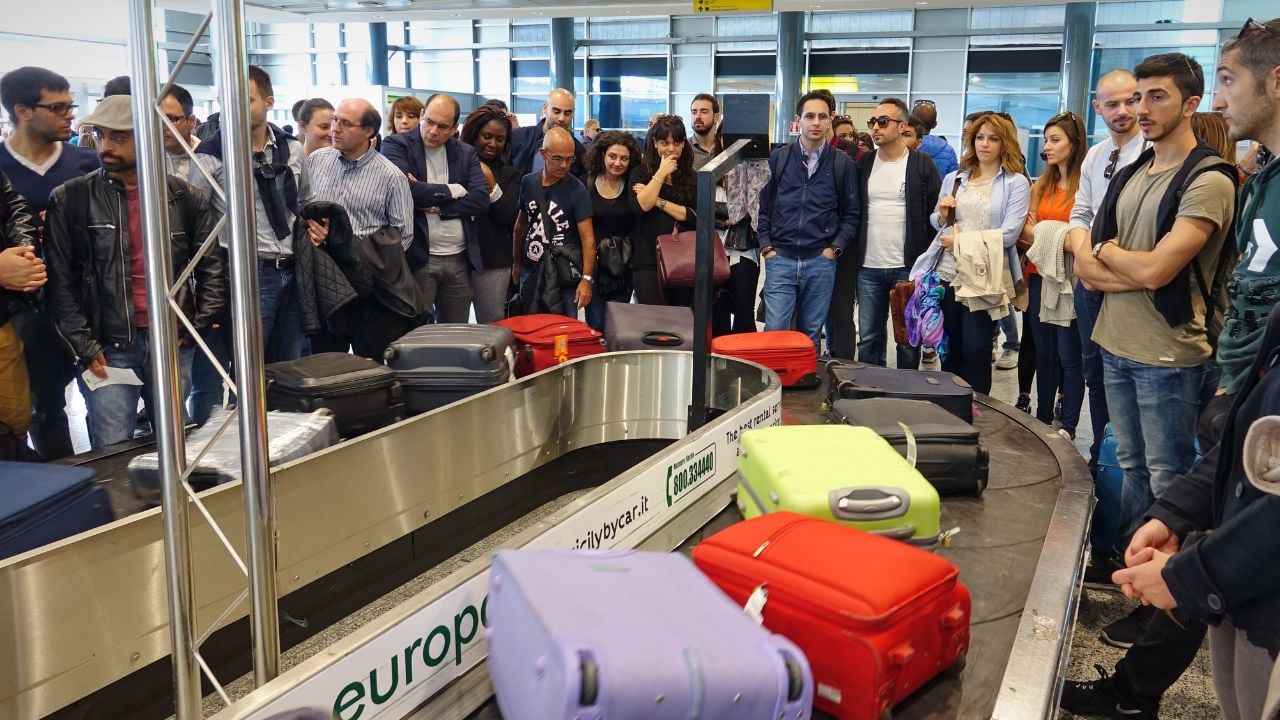 Cagliari, Italy - October 2017: Travelers waiting for their luggage at the baggage carousel