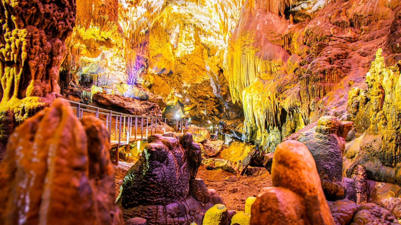 Illuminated rock formations inside Prometheus Cave