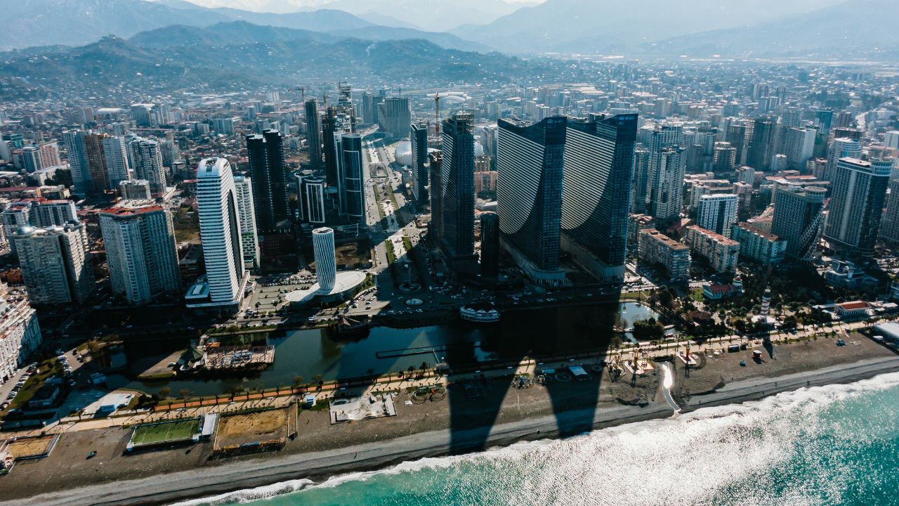 Aerial view of batumi city in georgia, showcasing modern skyscrapers, hotels, and residential buildings along the black sea coast, highlighting urban development and coastal tourism