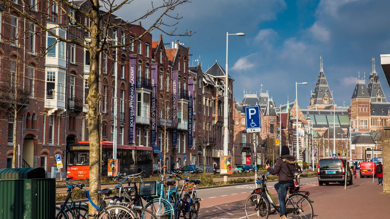 AMSTERDAM, NETHERLANDS - MARCH, 2018: Beautiful architecture and cyclists at the Old Central district in Amsterdam