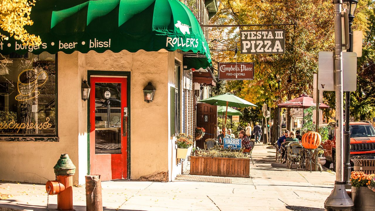 A charming street scene features outdoor seating and colorful storefronts, including a pizza place and restaurant. Chestnut Hill, Philadelphia, Pennsylvania, USA November 3, 2024