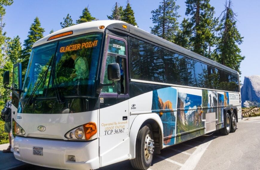 June 27, 2019 Yosemite National Park / CA / USA - The Yosemite Glacier Point guided tour bus, operated by Aramark, available from late May to early November; Half Dome visible in the background