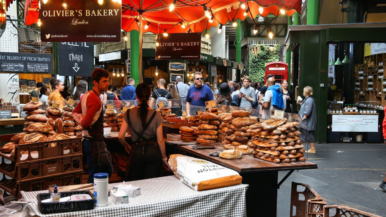 LONDON, UK - JULY 8, 2016: People visit a bakery at Borough Market in Southwark, London. It is one of oldest markets in Europe. Its 1,000th birthday was in 2014.