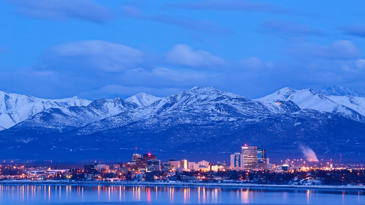 Anchorage Alaska skyline in winter at dusk with the Chugach mountains behind.