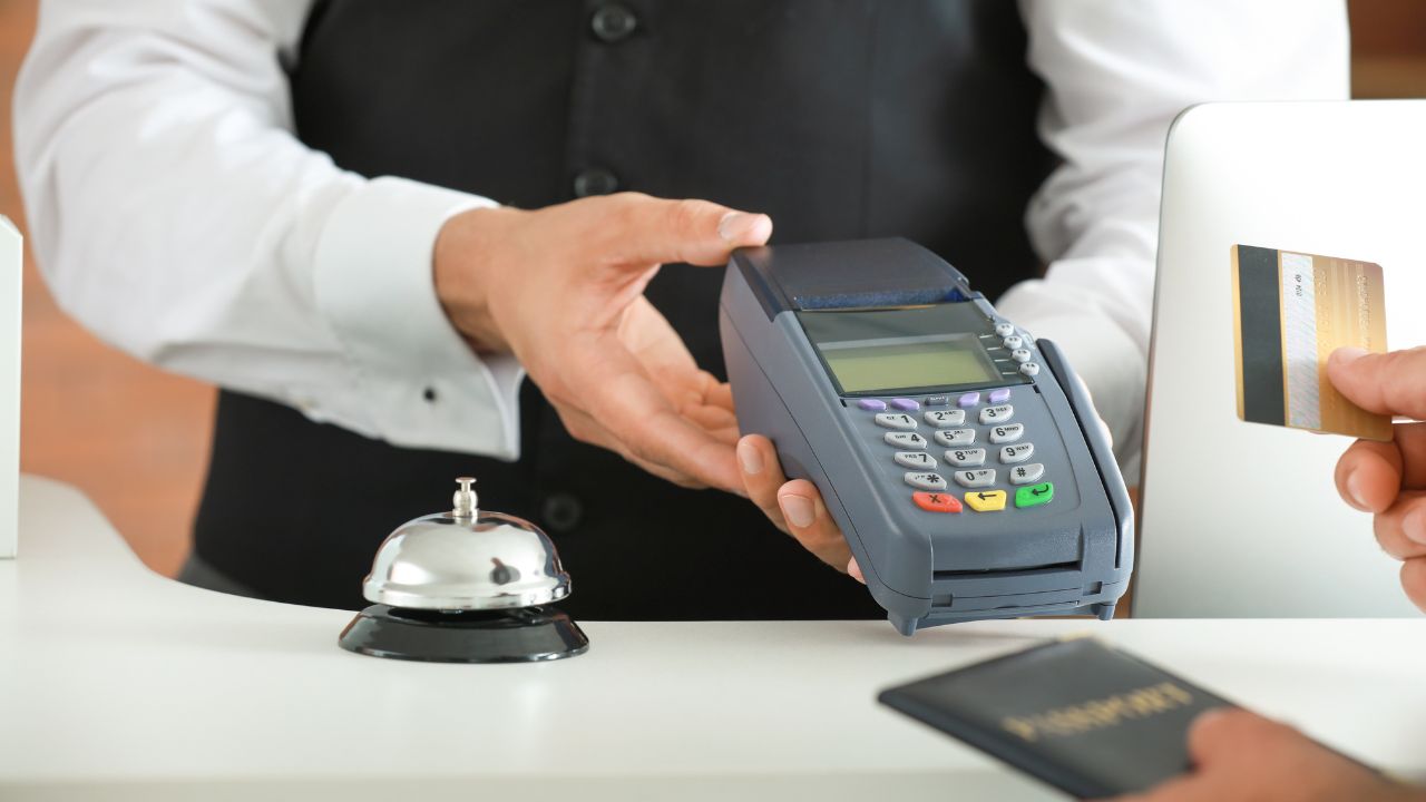 Man paying for hotel room at reception, closeup