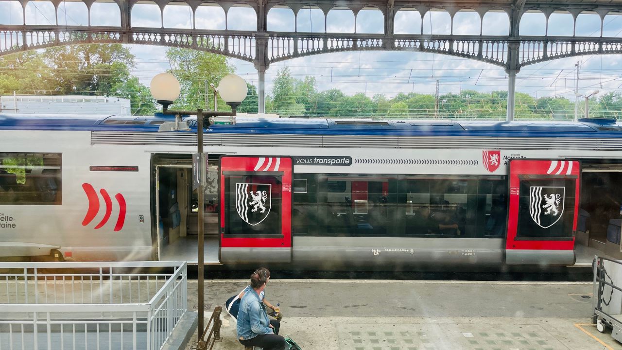 Paris, France, May 20 2023. Two people at the train station platform with travel bags waiting for a train in a station in France.