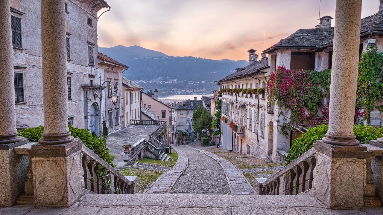 Beautiful scenic alley with historic and traditional houses and cobbled street at sunset. Old fashioned Italian village, Orta San Giulio (street Albertoletti), on lake Orta (lake d'orta), north Italy